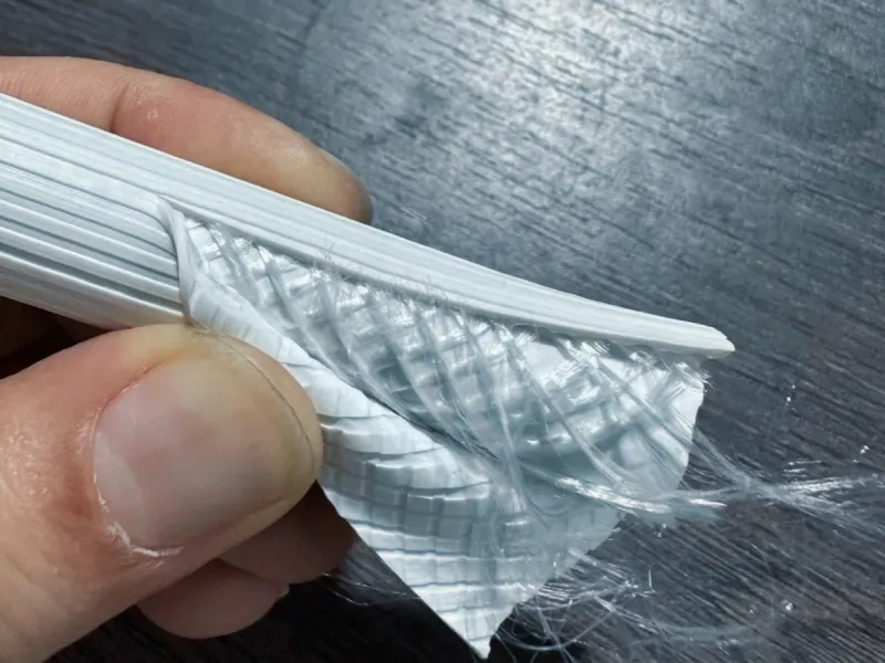 Cut-open PVC braided hose showing fine yarn reinforcement directly between the inner and outer PVC layers