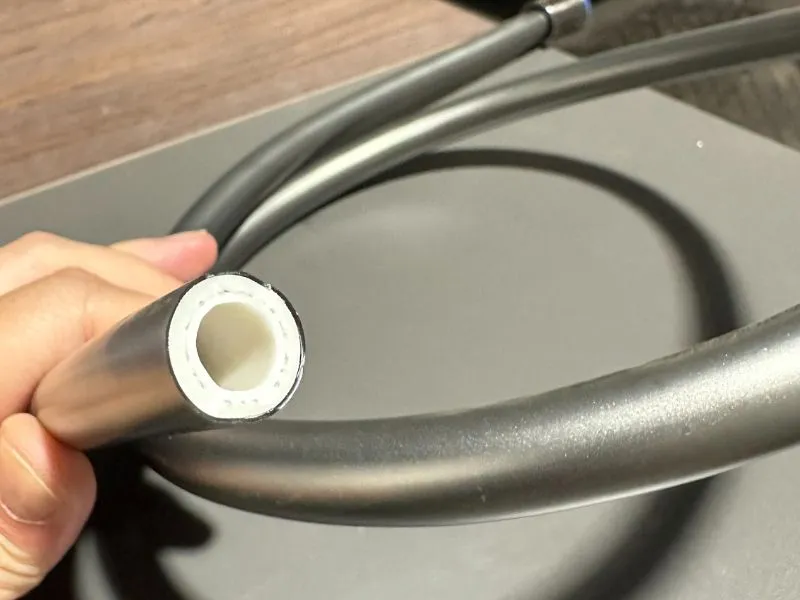 Smooth PVC shower hose sample with internal reinforcement and smooth outer PVC surface